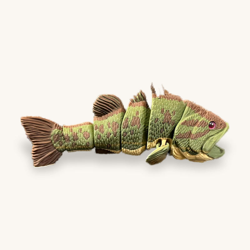 Green and brown 3D-printed articulated fish with segmented body and fanned tail on a plain background