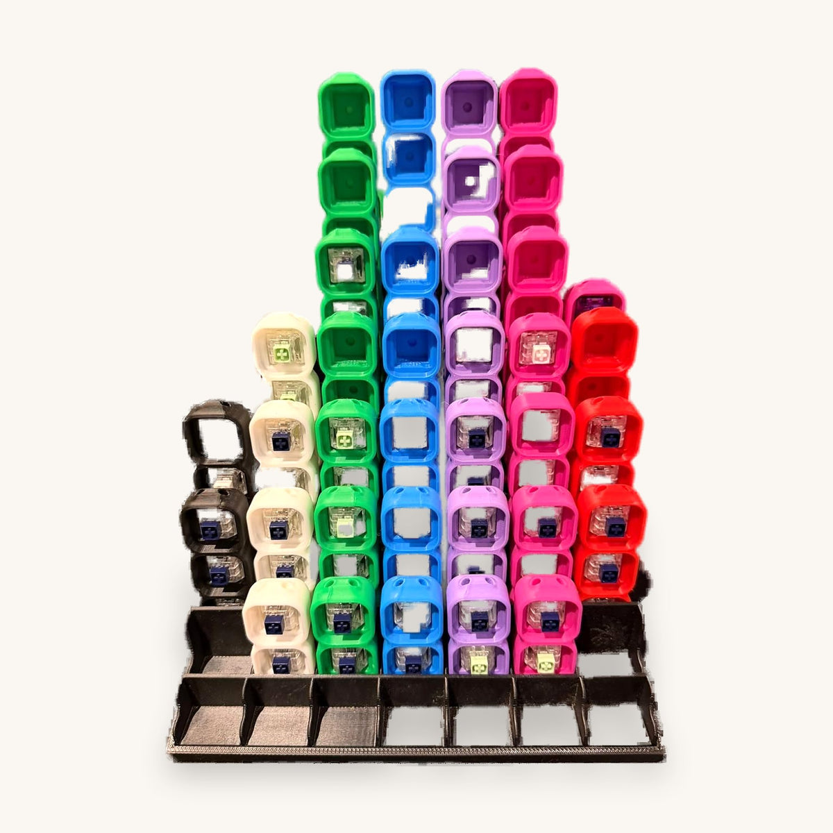 Display rack of 3D-printed mechanical keyboard switch fidgets in cream, green, blue, purple and pink