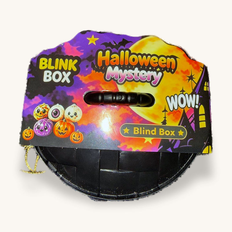 Black Halloween Blink Box blind-box tin with its purple and orange header card on a spiderweb cloth
